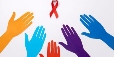 Mani colorate protese verso un fiocco rosso, simbolo della lotta contro HIV e AIDS