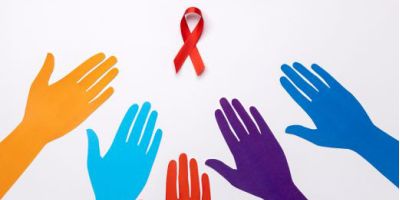 apre il dettaglio dell'articolo:Mani colorate protese verso un fiocco rosso, simbolo della lotta contro HIV e AIDS